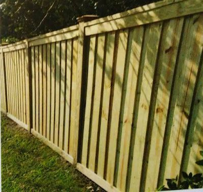 Wooden privacy fence in a grassy yard.