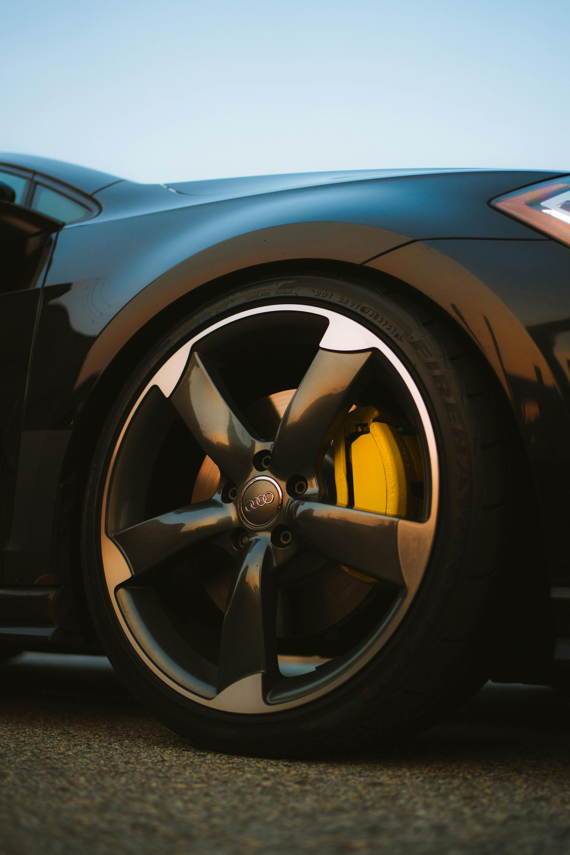 A close up of a brake disc and brake caliper on a car.