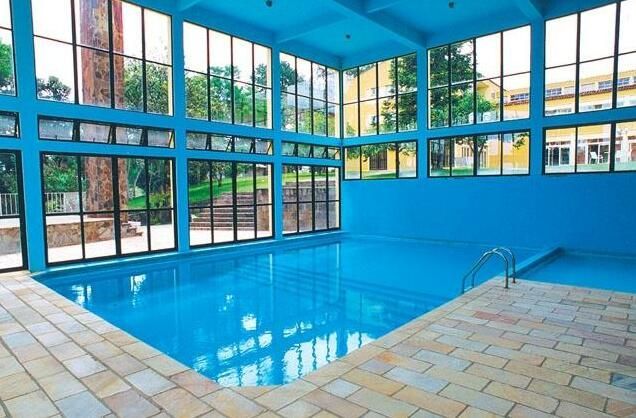 Uma grande piscina coberta com muitas janelas