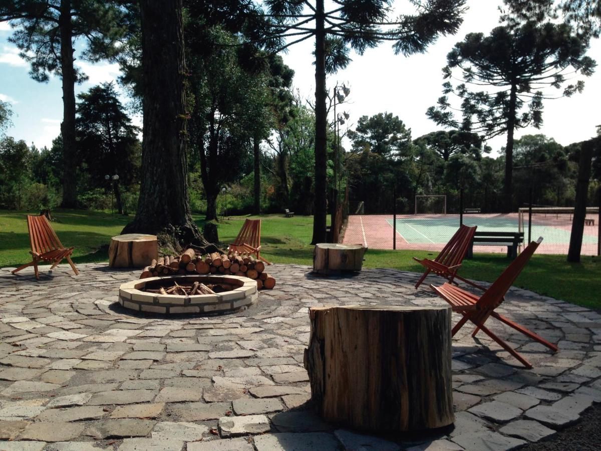 Uma fogueira cercada por cadeiras e uma quadra de tênis