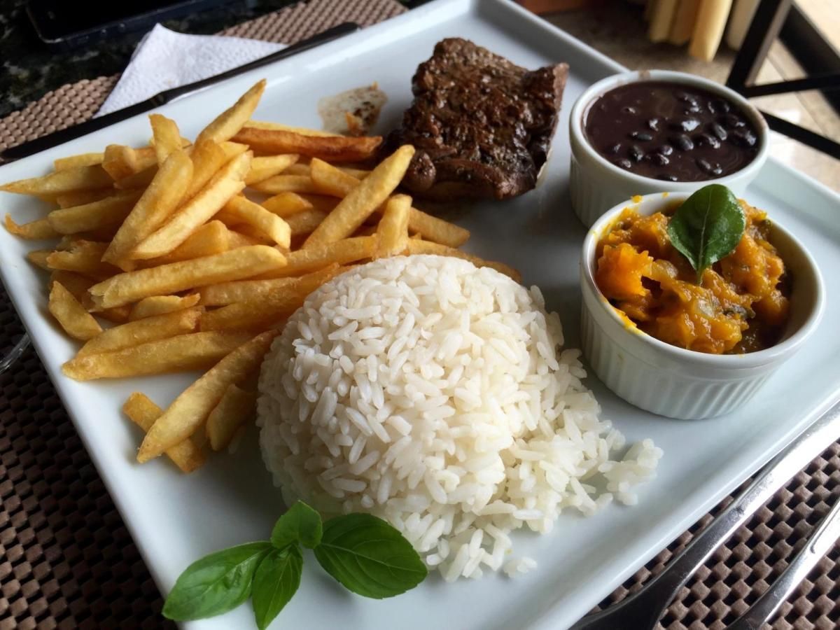Um prato branco coberto com arroz e batatas fritas