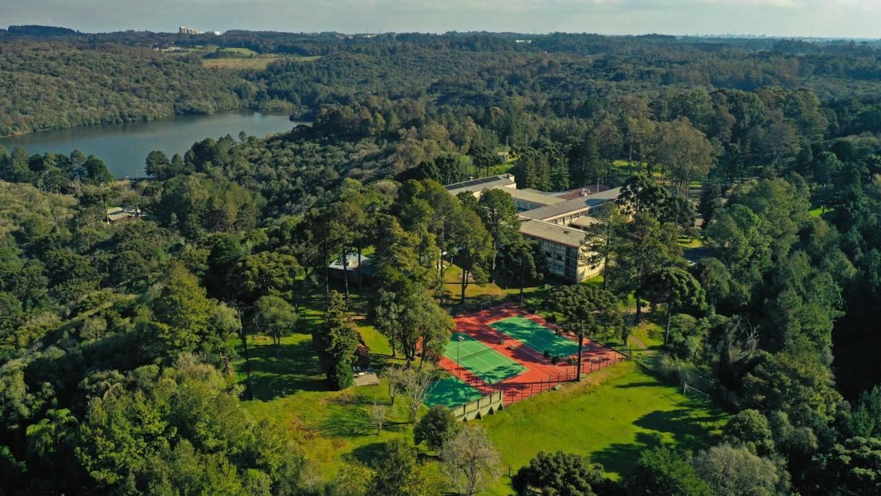 Uma vista aérea de um parque cercado por árvores e um lago.