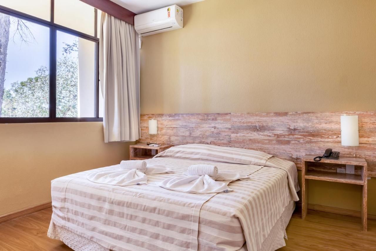 Um quarto de hotel com uma cama e uma janela.