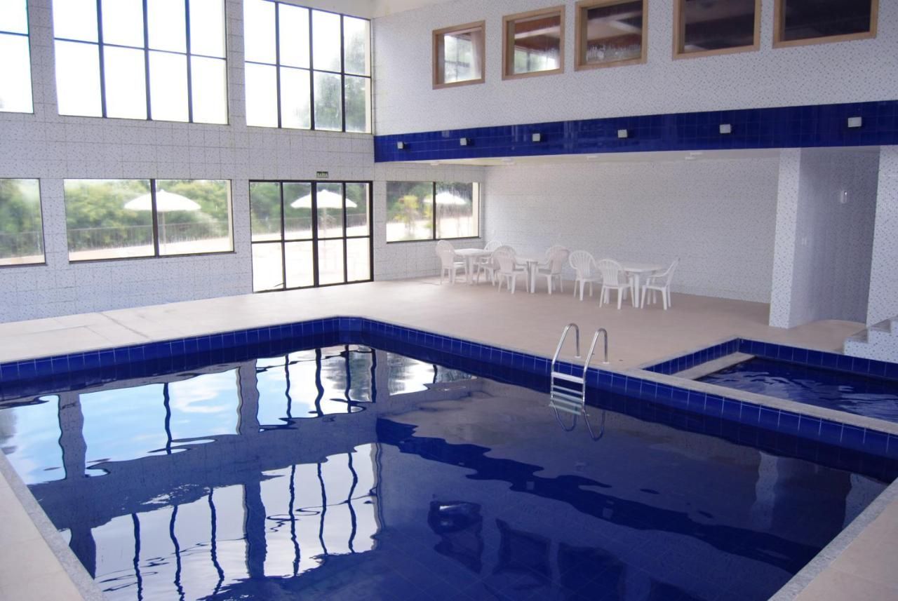 Uma grande piscina coberta com mesas e cadeiras ao redor