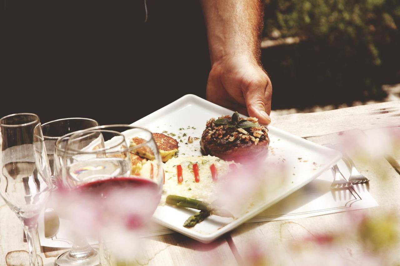 Uma pessoa está pegando um pedaço de comida de um prato sobre a mesa.