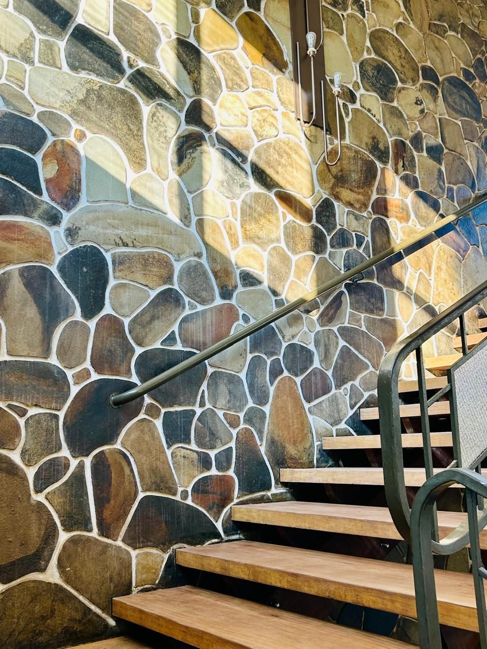 Escadas que levam a um muro de pedra com corrimão