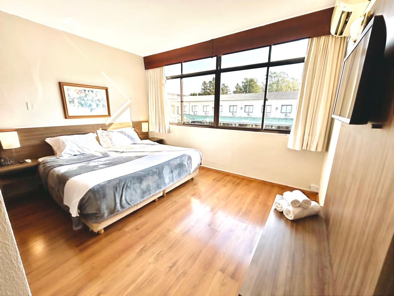 Um quarto de hotel com uma cama king size e uma TV de tela plana.