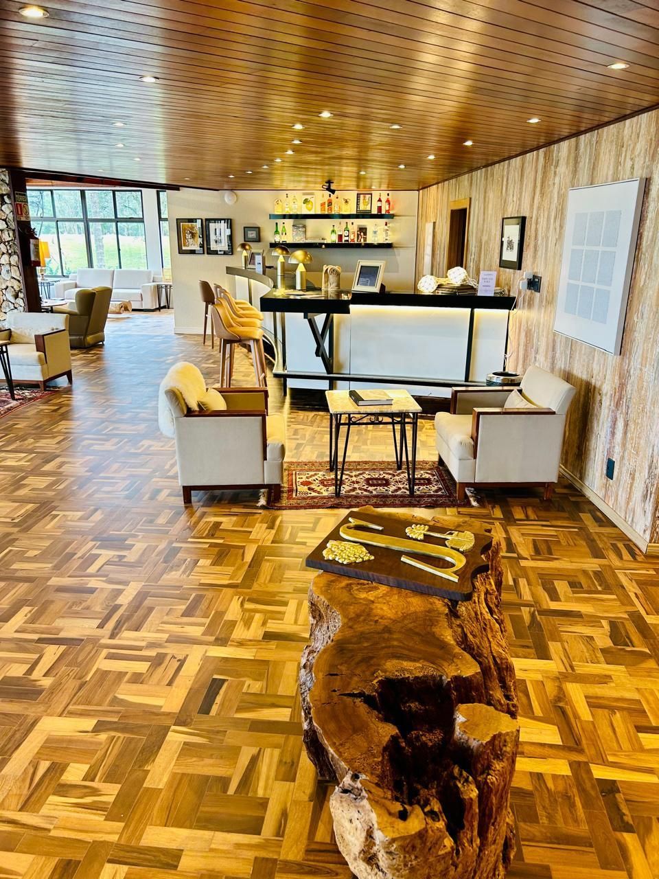 Uma sala de estar com piso de madeira e uma mesa de madeira.