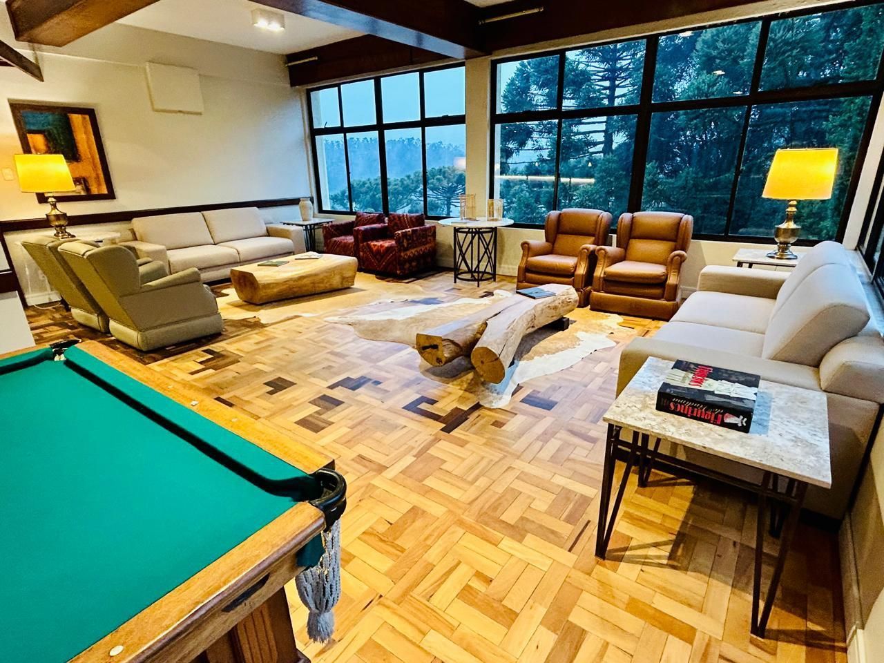 Uma sala de estar cheia de móveis e uma mesa de sinuca.