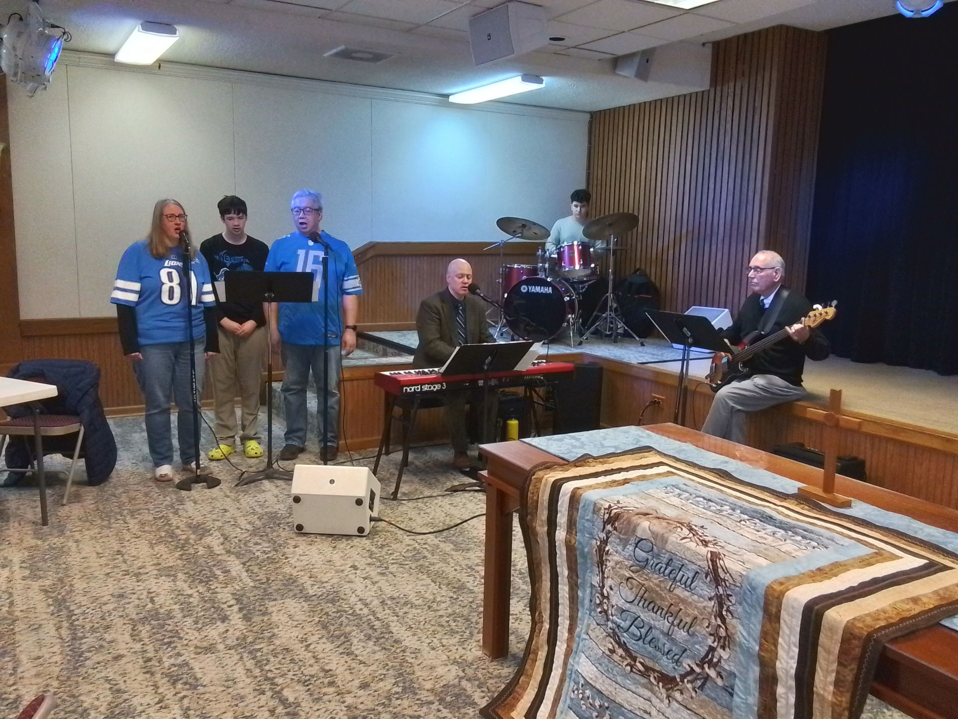 Praise Team members sing during a service in fellowship hall.