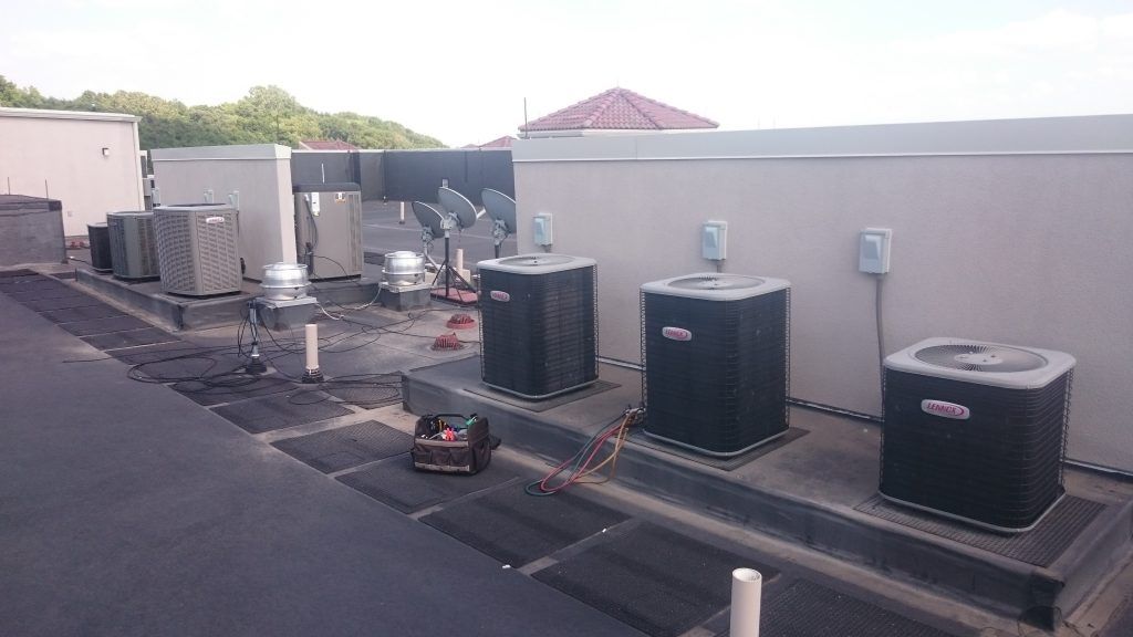 Rooftop with several air conditioning units and a small generator.