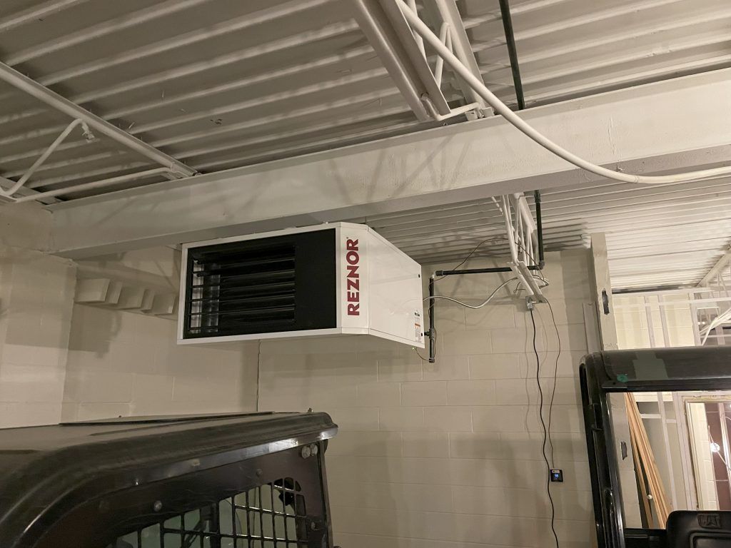 White Reznor heater mounted on a ceiling in an industrial space.