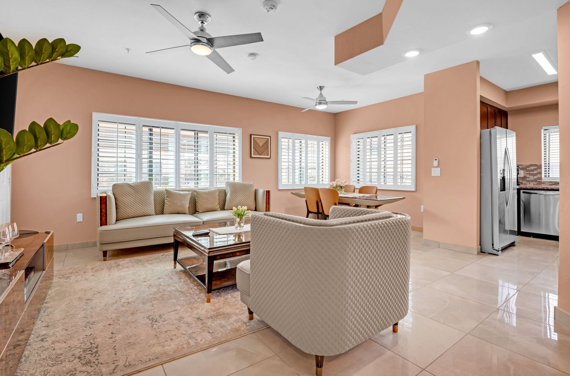 Living room with peach walls, furniture, and windows.