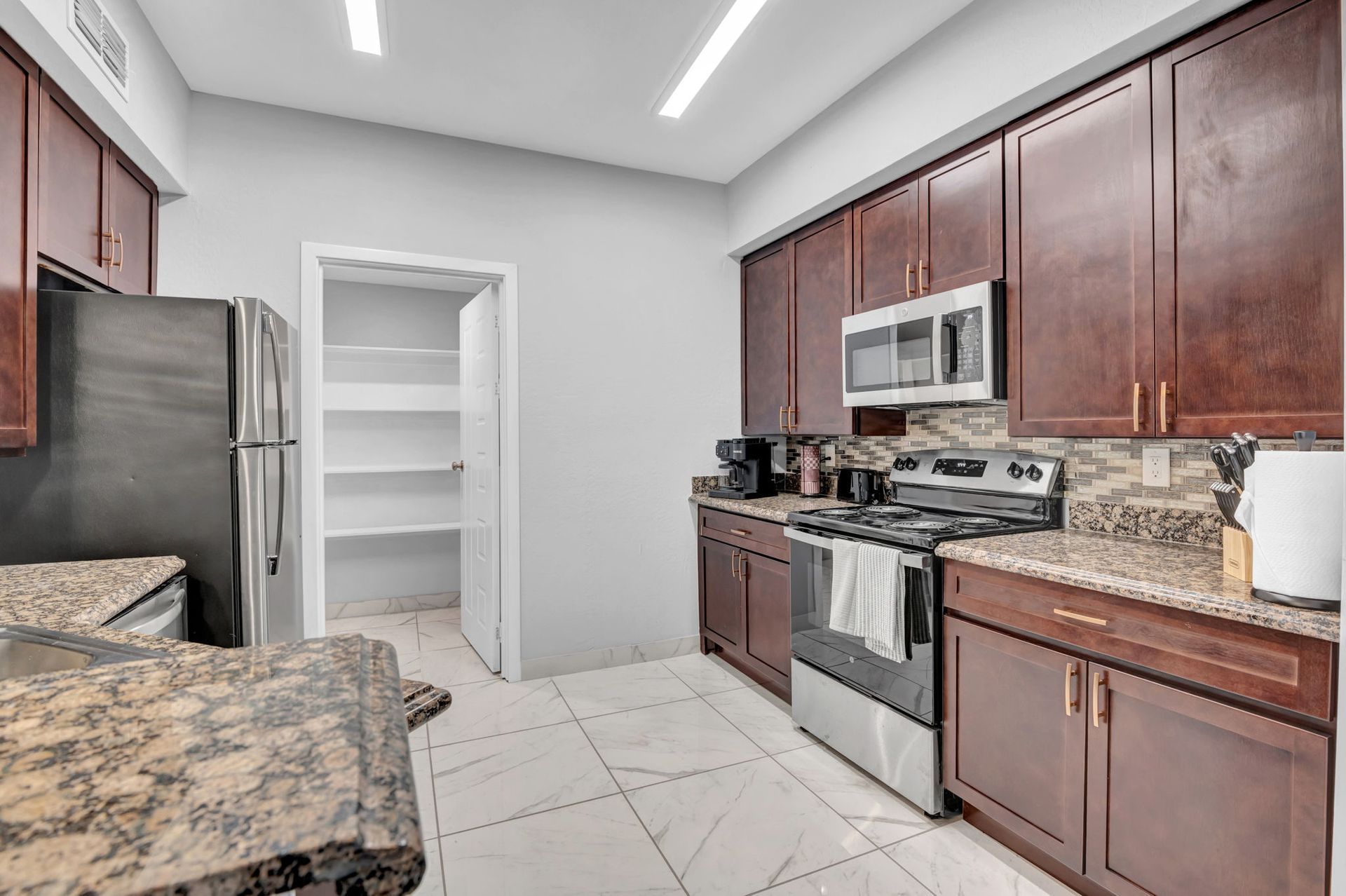 Kitchen with brown cabinets, stainless steel appliances, and granite countertops.