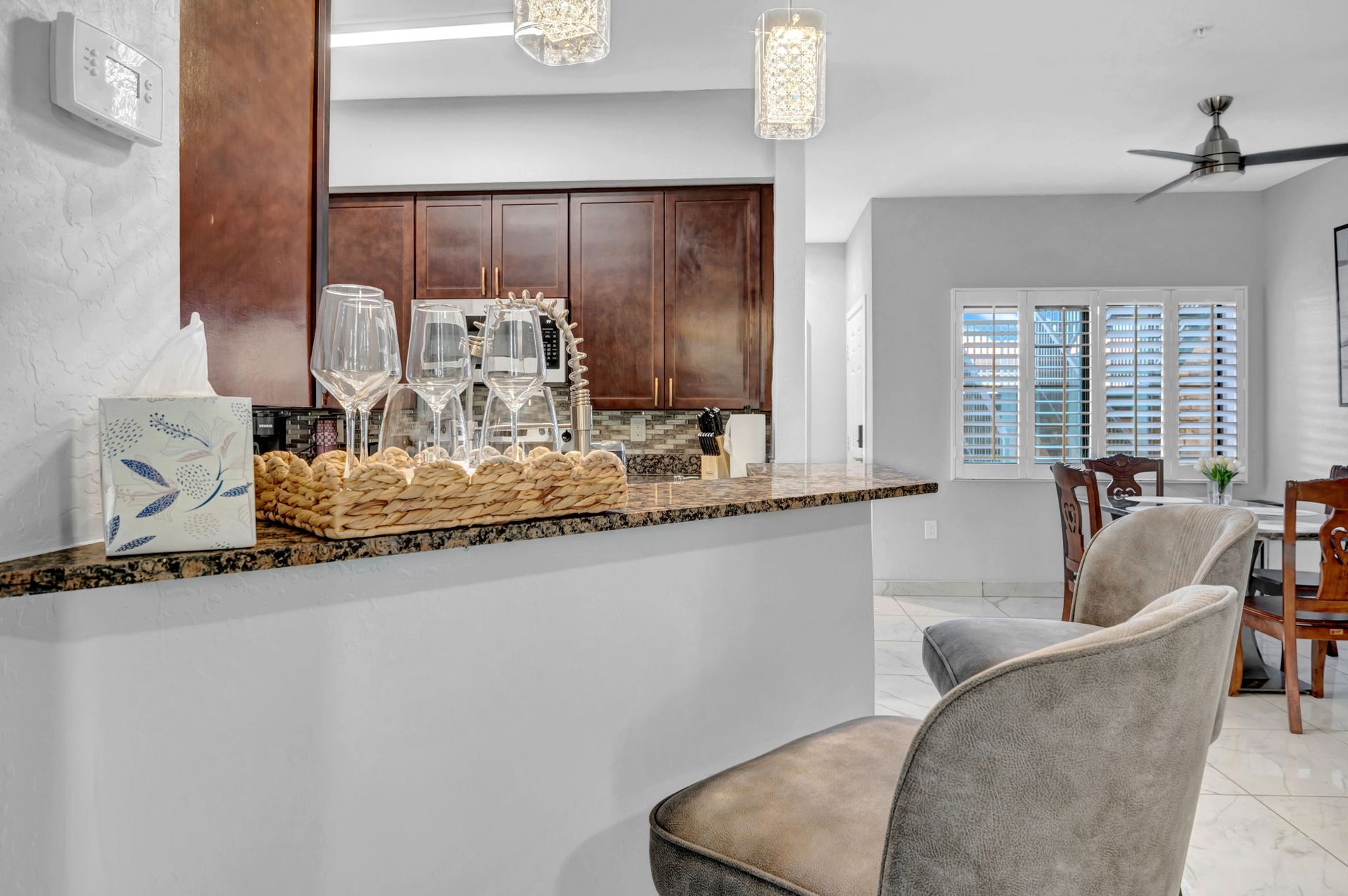 Interior view of kitchen and dining area with bar seating and decorative lighting.
