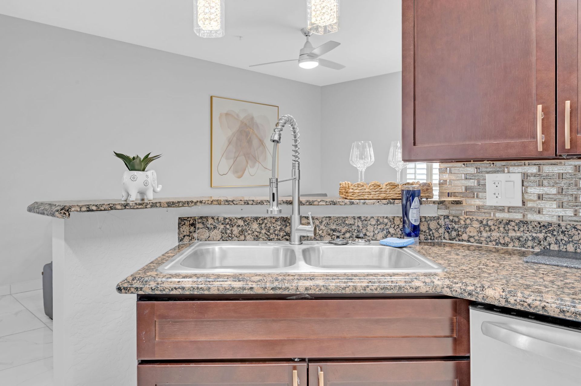 Kitchen with double sink, granite countertops, and dark wood cabinets.