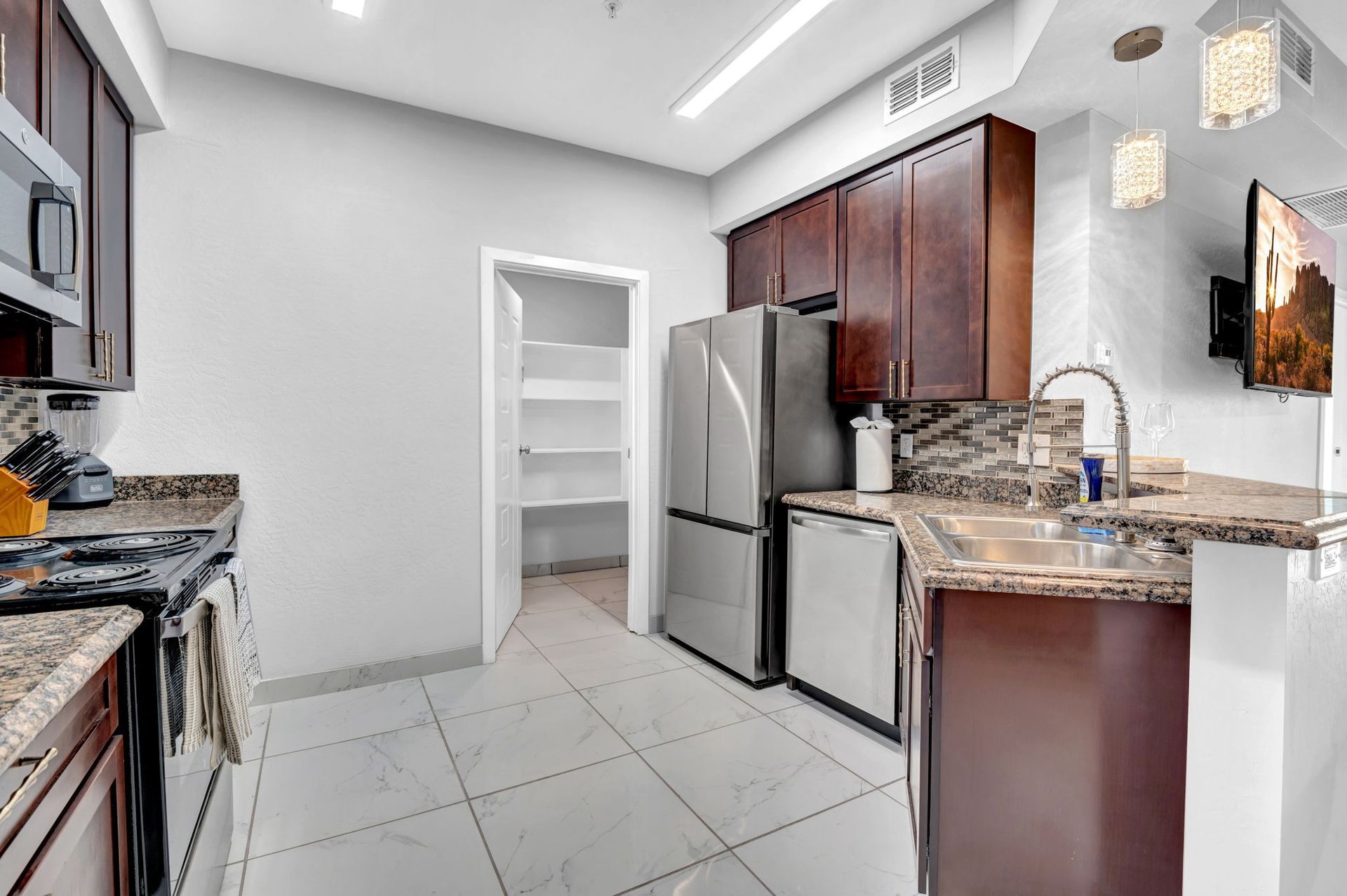 Kitchen with dark brown cabinets, stainless steel appliances, and a pantry.