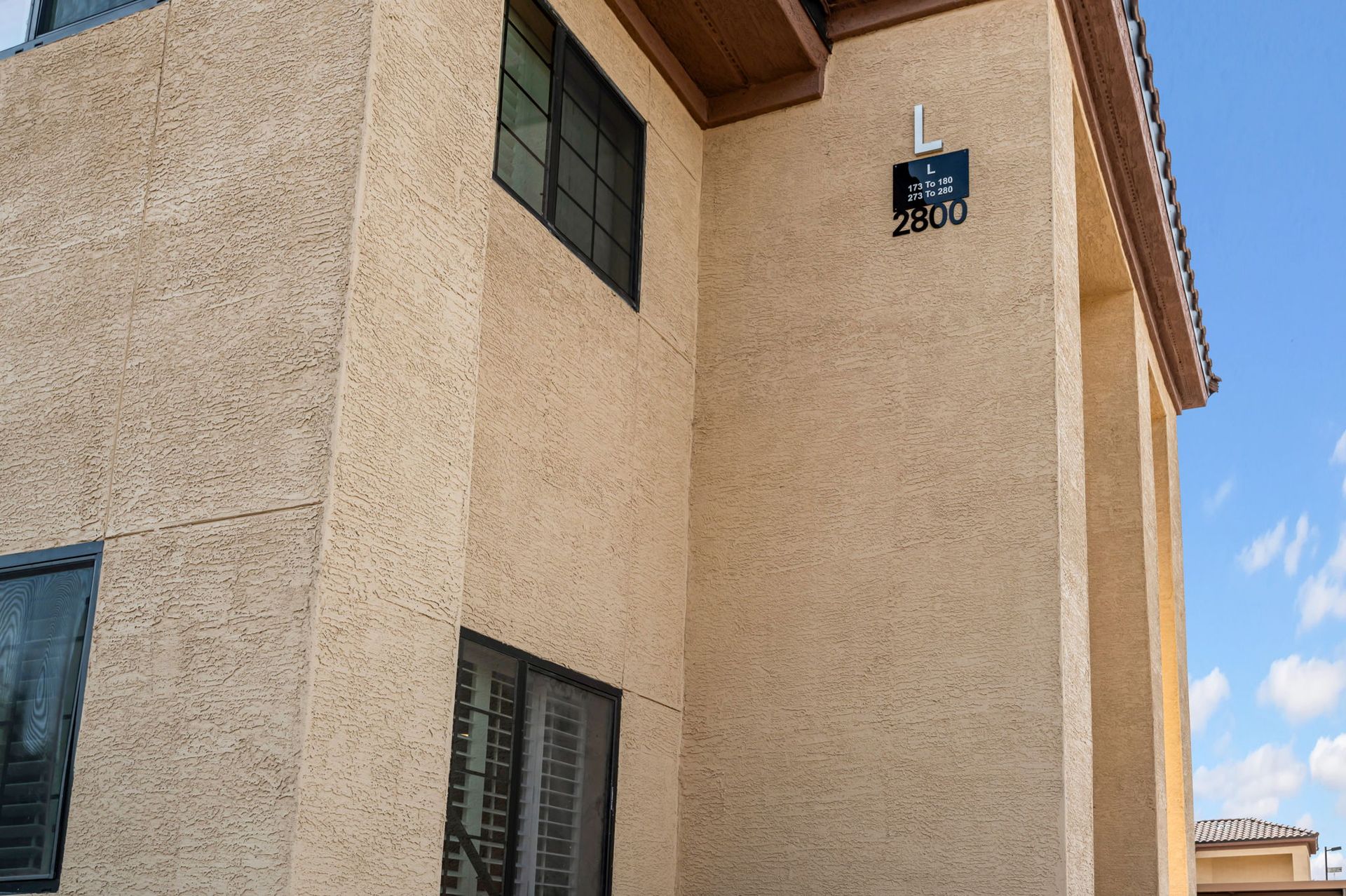 Beige stucco building with dark windows and address plaque: 2800.