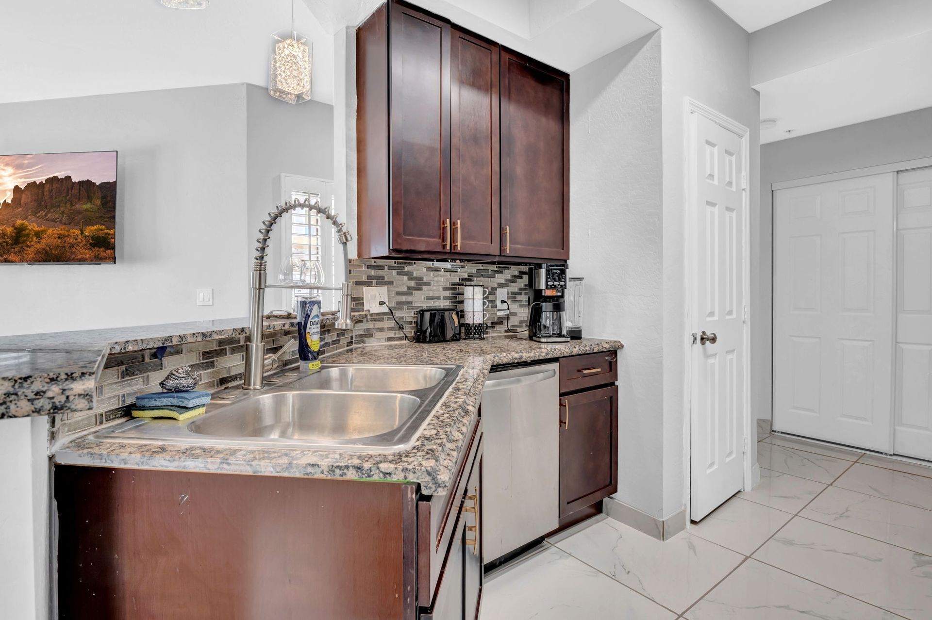 Kitchen with brown cabinets, stainless steel appliances, and granite countertops.
