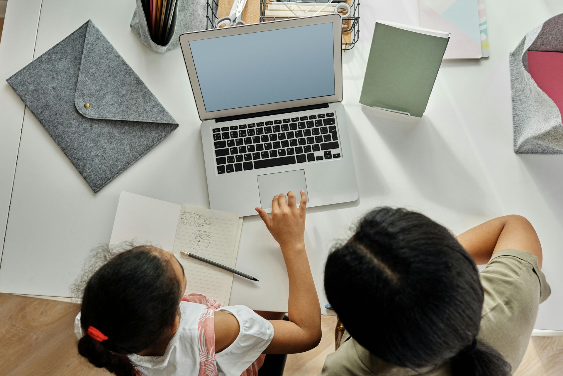Two people sitting at a lap top computer