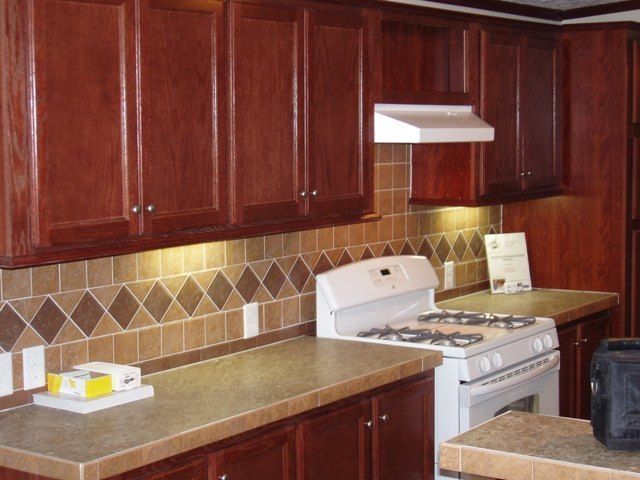 A kitchen with wooden cabinets and a white stove