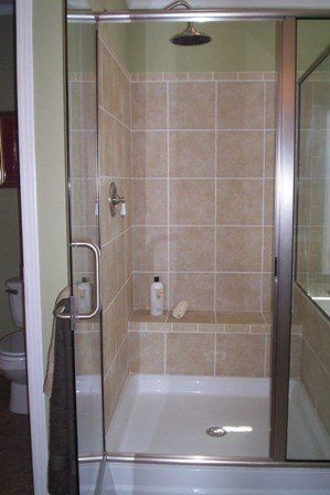 A bathroom with a walk in shower and a toilet.