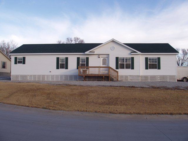 A white house with a black roof and green shutters