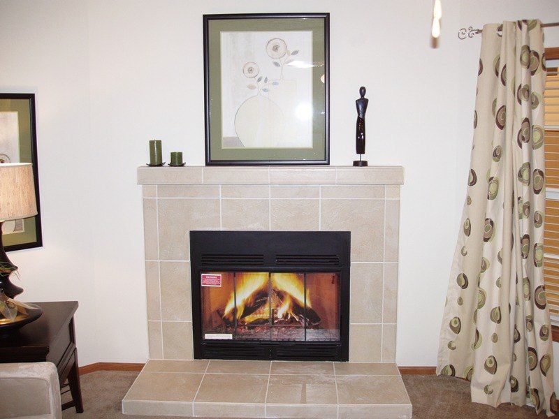 A living room with a fireplace and a picture on the mantle