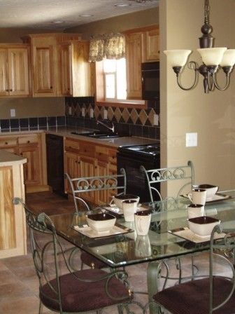 A kitchen and dining room with a glass table and chairs