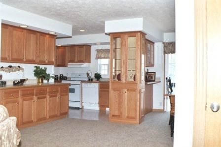 A kitchen with wooden cabinets and a white stove