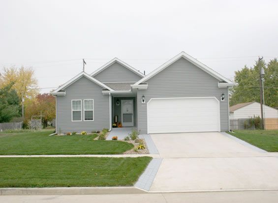 A gray house with a white garage door and a driveway