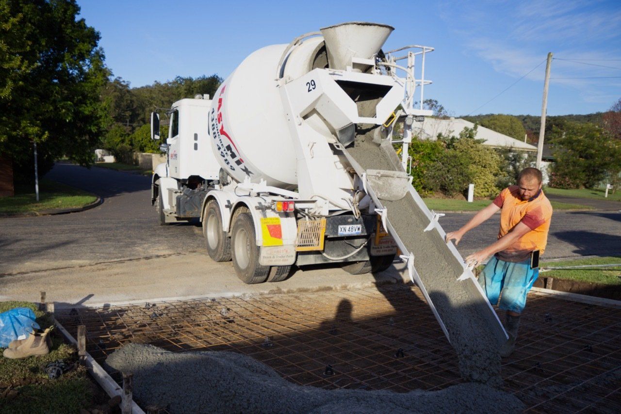 Man Pouring And Finishing A Concrete Driveway — Easy Mix Concrete in Berkeley Vale, NSW