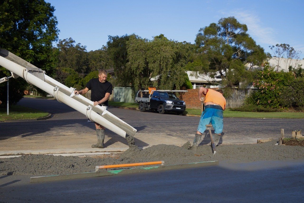Two Men Are Pouring Concrete Into a Driveway — Easy Mix Concrete in Berkeley Vale, NSW