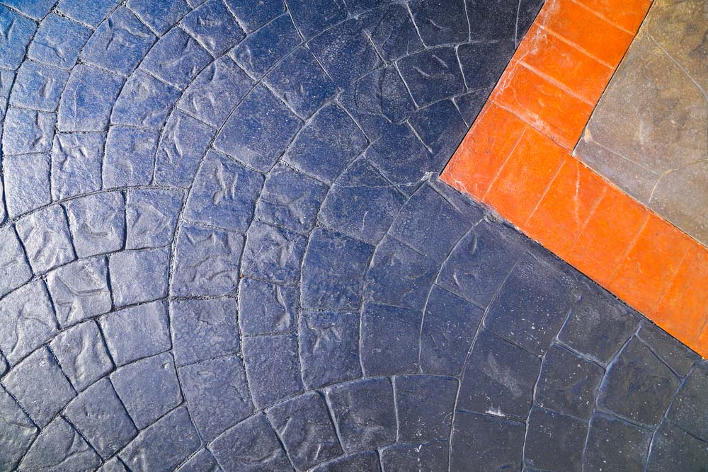 A Close up Of a Brick Floor with A Blue and Orange Border — Easy Mix Concrete in Berkeley Vale, NSW