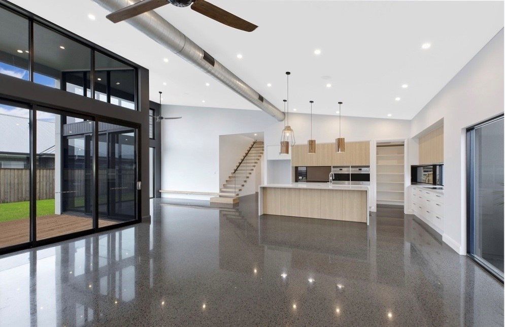 A Large Empty Room with A Kitchen and A Ceiling Fan — Easy Mix Concrete in Berkeley Vale, NSW