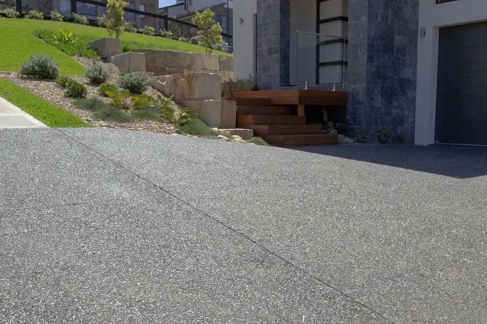 A Driveway Leading to A House with A Garage and Stairs — Easy Mix Concrete in Berkeley Vale, NSW