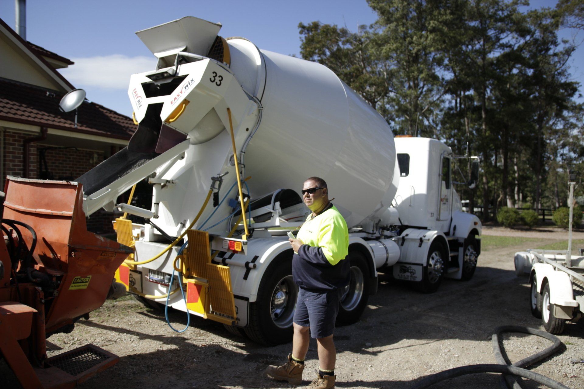 Concreter Standing Beside Mixer Truck — Easy Mix Concrete in Berkeley Vale, NSW