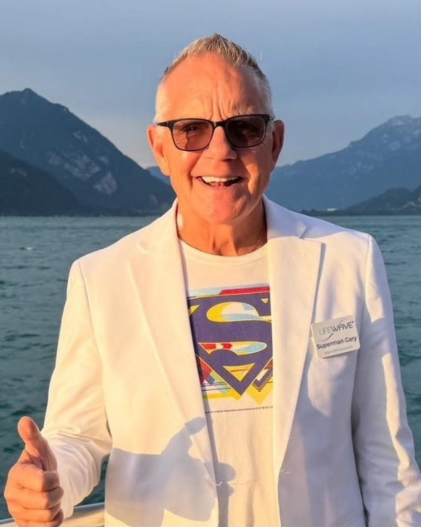 A woman is standing in front of a white wall with her arms crossed.