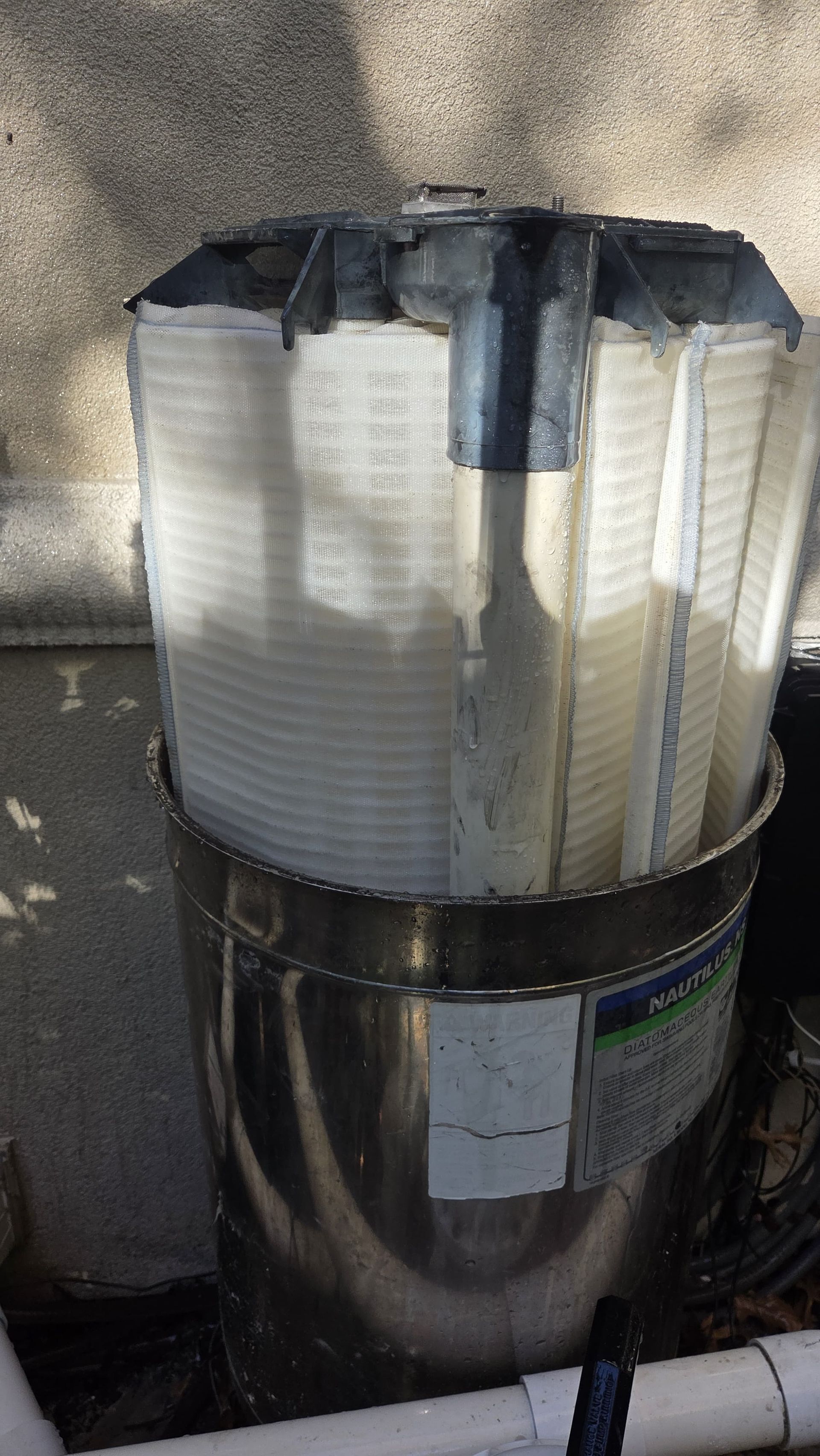 Stainless steel water filter with a white pleated filter inside.