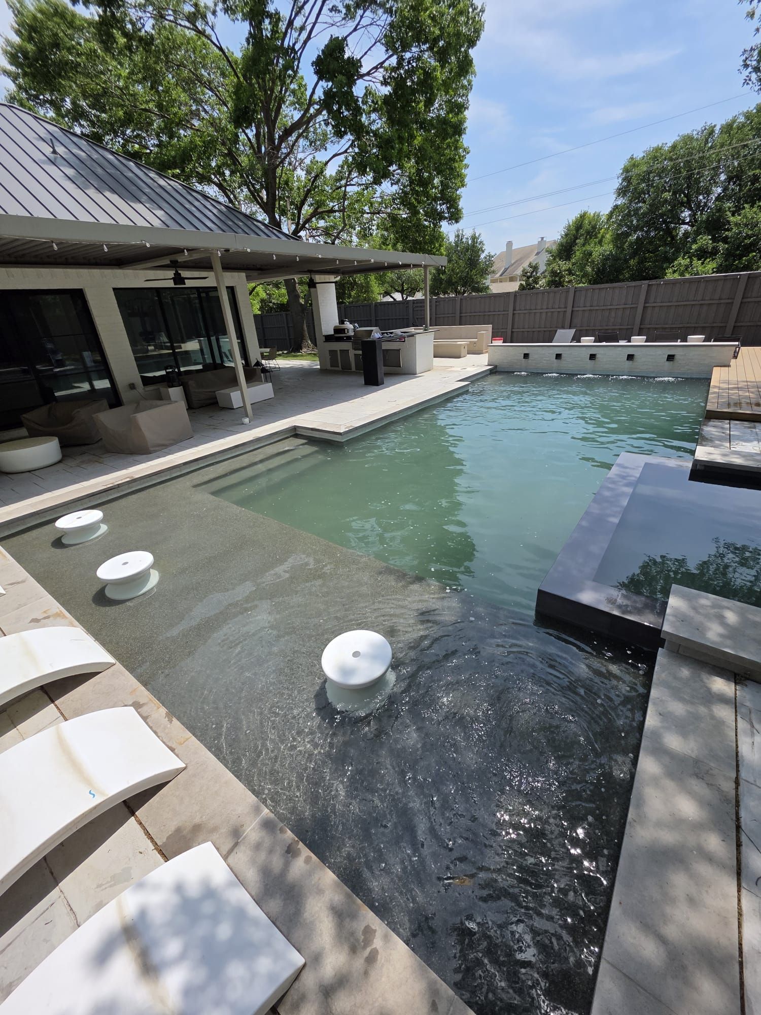 Luxury backyard pool with a covered patio and bar.
