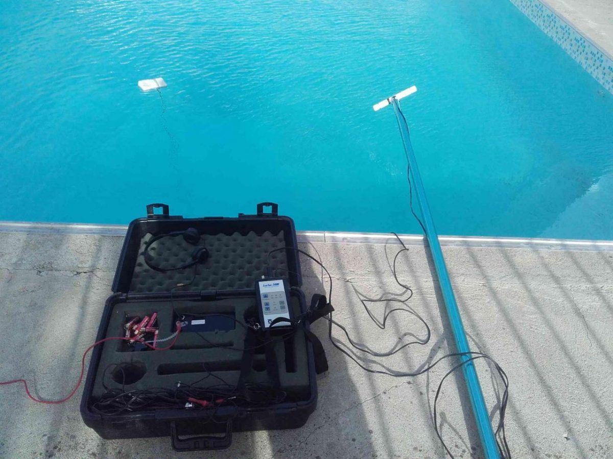 Black case with equipment and a pole extended into a blue pool.