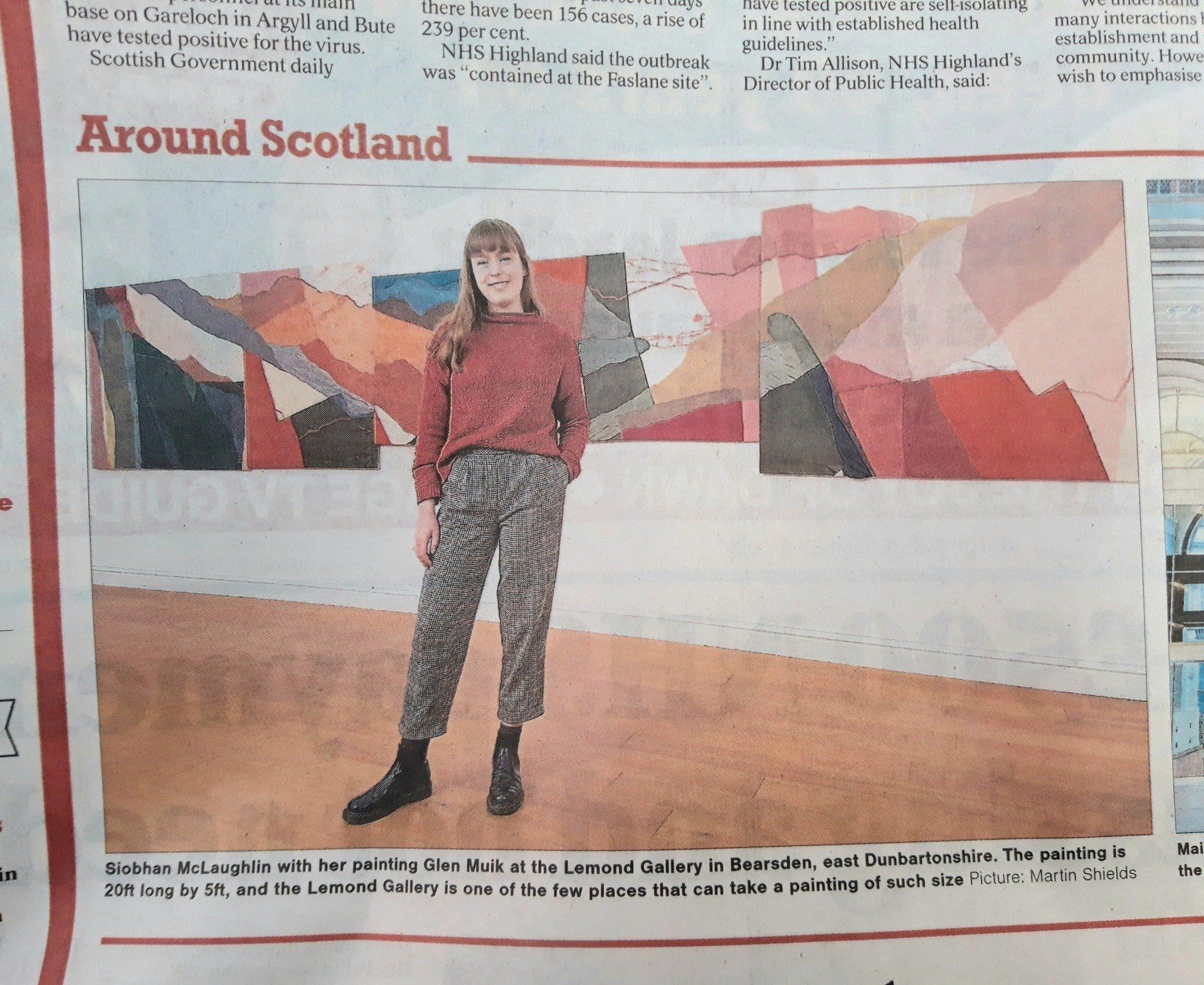 Newpaper cutting of artist standing in gallery space with paintings on the wall