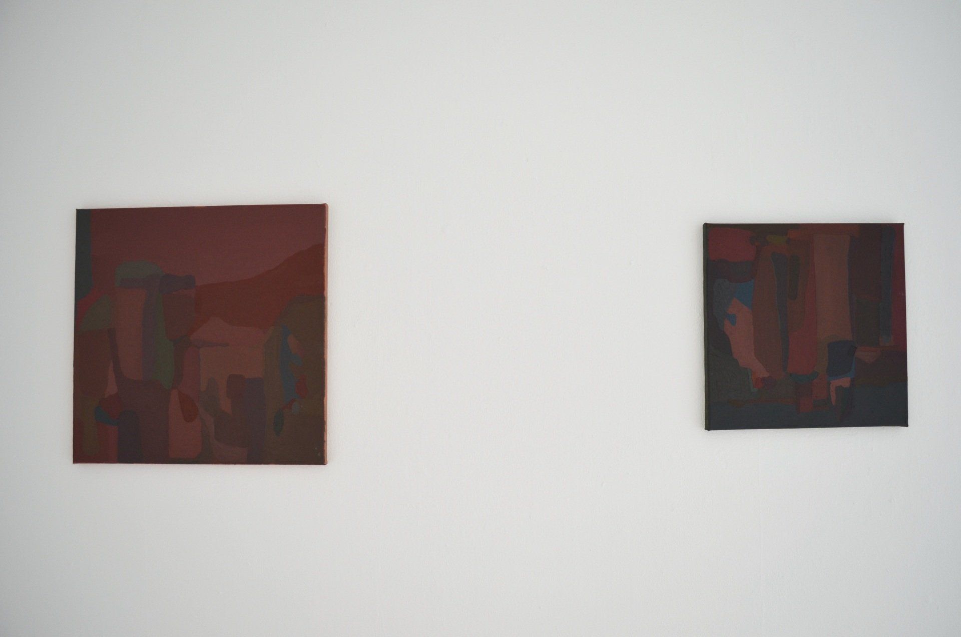 Two abstract painting hanging on white gallery wall