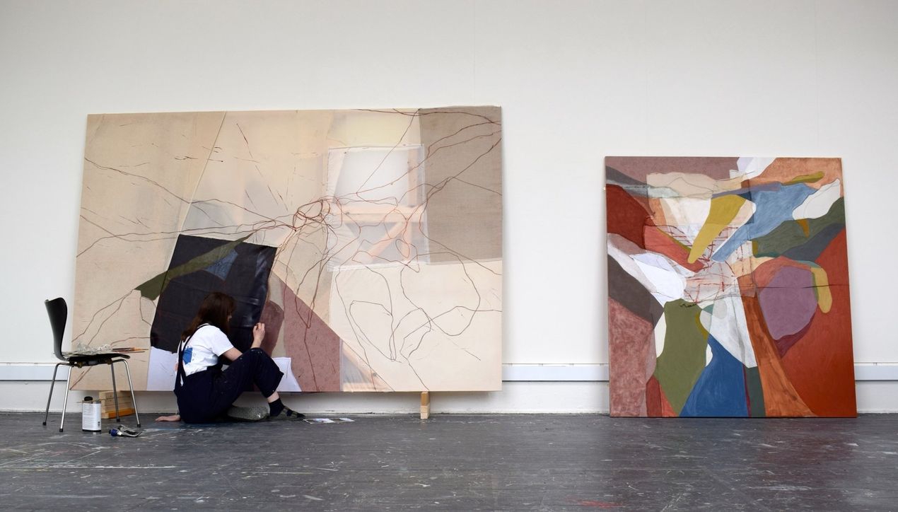 Artist Siobhan McLaughlin sitting in art school studio, working on large scale abstract painting