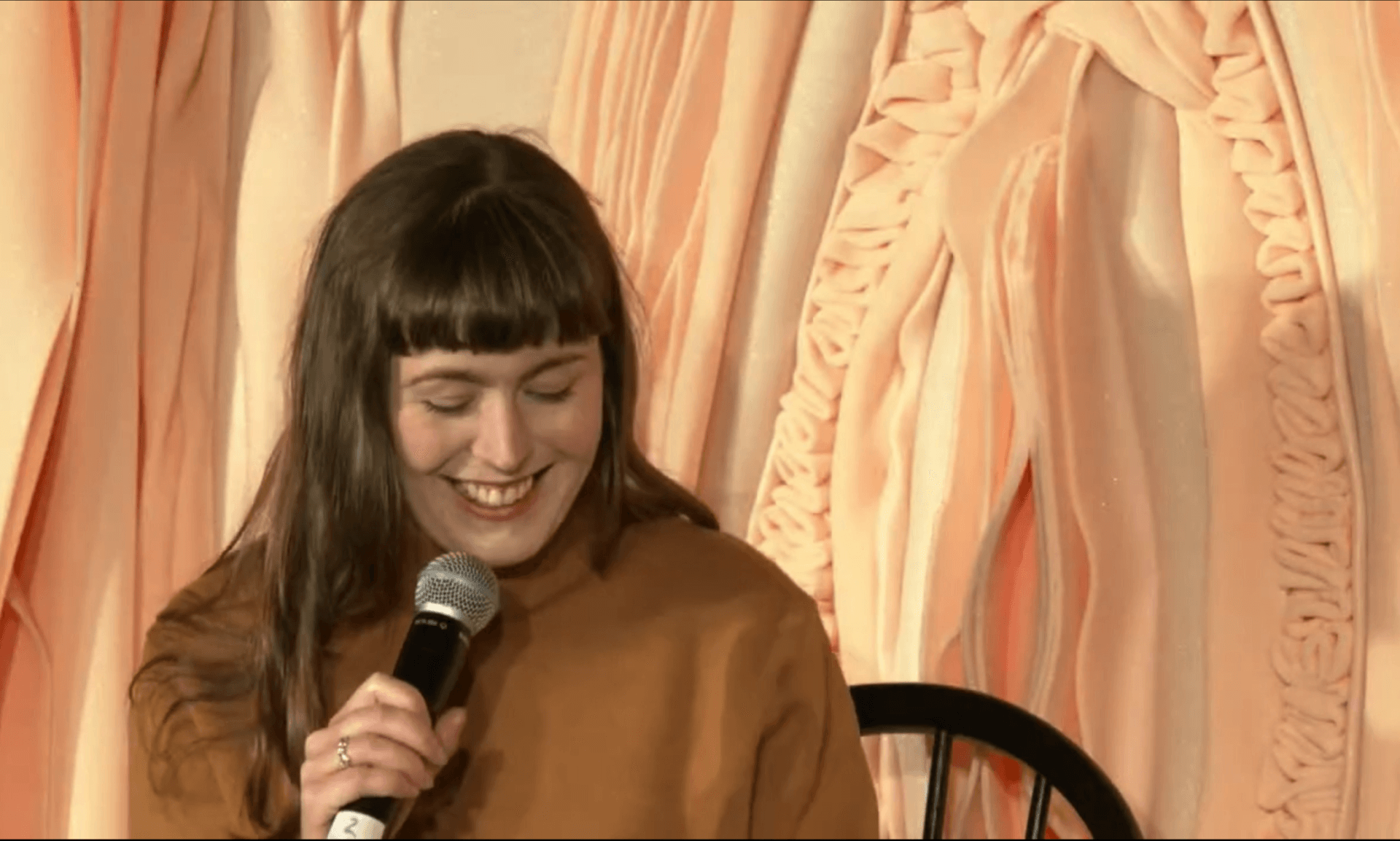Photo of artist Siobhan McLaughlin smiling with a microphone