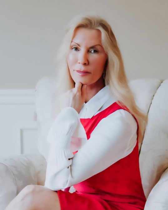 A woman in a red dress and white shirt is sitting in a chair