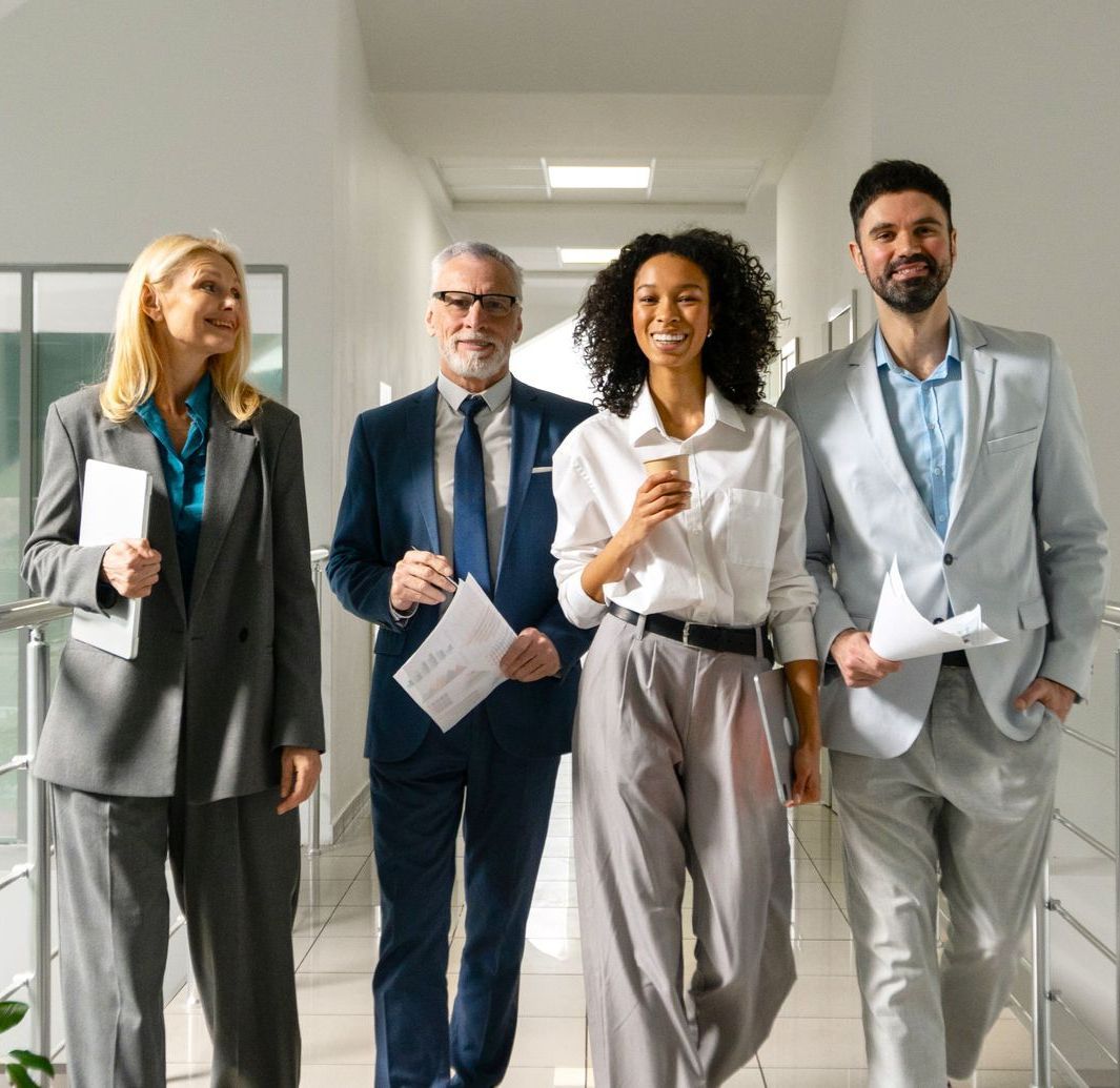 A group of business people are walking down a hallway.