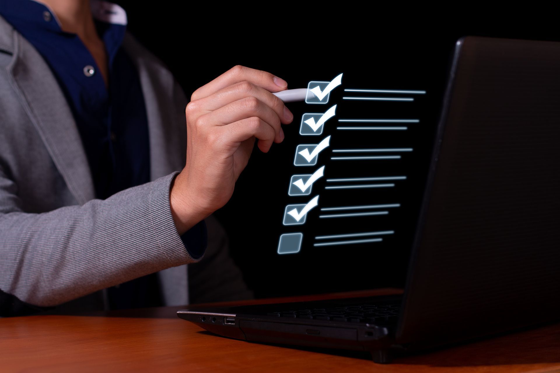 A person is using a laptop with a checklist on the screen