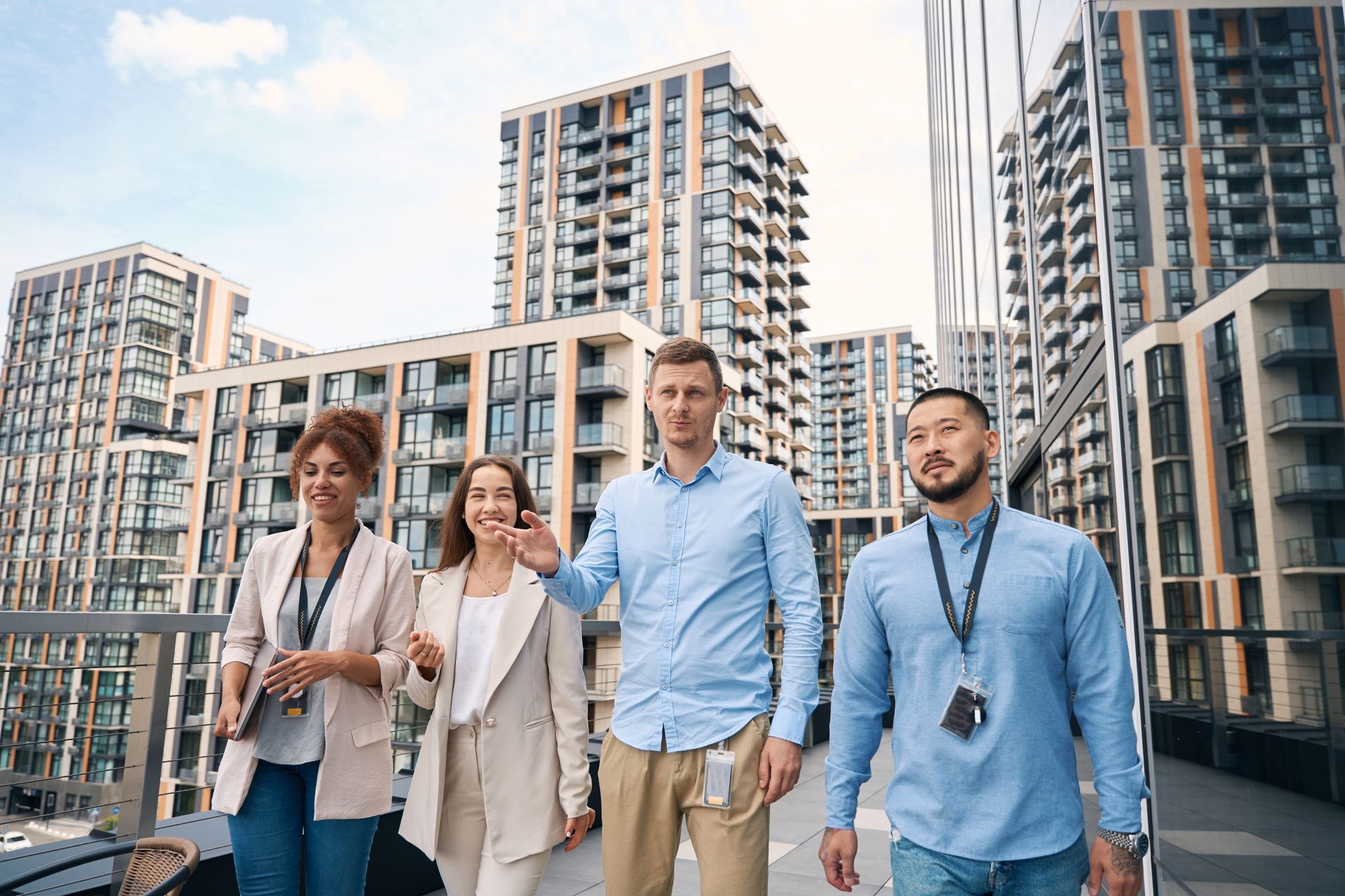A group of people are walking in front of tall buildings.