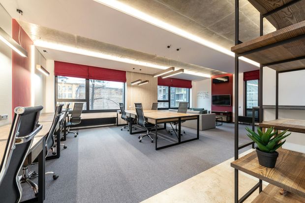 A large open office with a lot of desks and chairs.
